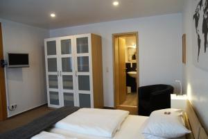 a bedroom with two beds and a door to a bathroom at Bei Meier`s zum weißen Roß in Königslutter am Elm