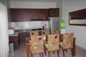 a kitchen with a table and chairs in a kitchen at The Green Kamboja Villa in Sanur