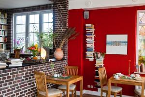 a dining room with red walls and two tables and chairs at Haus am Meer in Scharbeutz
