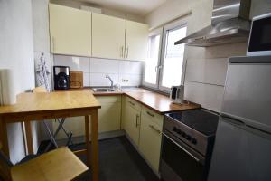 a kitchen with white cabinets and a stove top oven at Work & Stay Ferienhaus Niederkassel in Rheidt