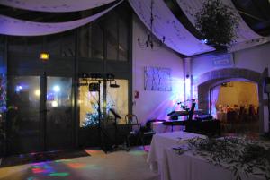 a room with purple lighting and a table with a camera at Logis Le Relais Fleuri in Sauvigny-le-Bois