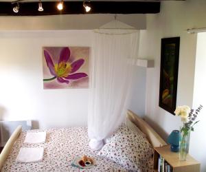 a bedroom with a bed with a curtain and a table at PRIVATE POOL with Stunning Views of the Chateau!! Old Barn in Rouffignac Saint-Cernin