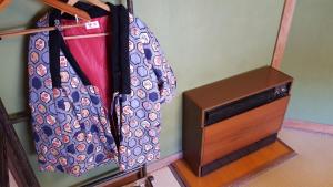 a bag hanging on a wall next to a drawer at Ryokan Maruya in Yufu