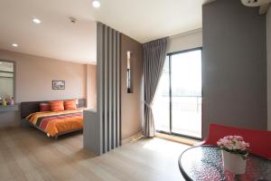 1 dormitorio con cama y ventana grande en Live at Home Sukhumvit 105, en Bangkok