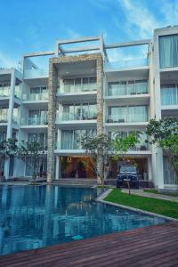 a building with a swimming pool in front of it at Triple O Six in Mirissa