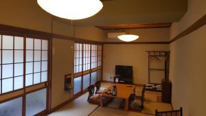 a living room with a table and chairs and a light at Ryokan Maruya in Yufu