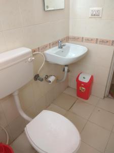 a bathroom with a white toilet and a sink at Vega Residency in Bangalore