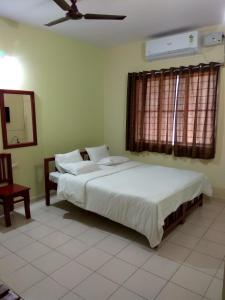 a bedroom with two beds and a ceiling fan at Vega Residency in Bangalore