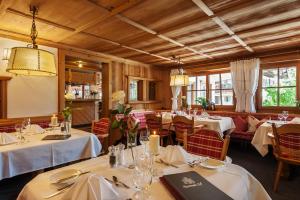 a restaurant with tables and chairs with white table cloth at Wohlfühlhotel Berwanger Hof in Obermaiselstein