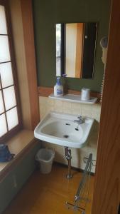 a bathroom with a white sink and a mirror at Ryokan Maruya in Yufu +29 photos