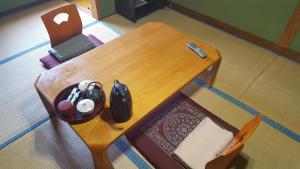 a small wooden table with a remote control on it at Ryokan Maruya in Yufu