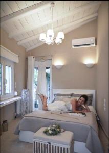 a woman laying on a bed in a bedroom at Meni Sweet Luxury Home in Volos