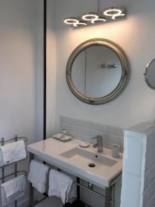 een badkamer met een wastafel en een spiegel aan de muur bij Les Colonnes De Chanteloup in Amboise