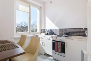 una cucina con elettrodomestici bianchi, tavolo e finestra di Apartament Libelta a Poznań