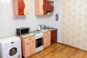 Una pequeña cocina con fogones, lavadora y secadora. en ATLANT Apartments 214 en Voronezh