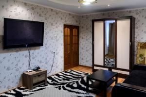 sala de estar con TV de pantalla plana en la pared en ATLANT Apartments 214 en Voronezh