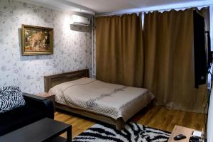 1 dormitorio pequeño con 1 cama y 1 sofá en ATLANT Apartments 214 en Voronezh