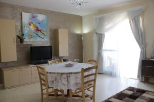 a dining room with a table and chairs and a television at Seafront Apartment - Balcony over the Harbour in Marsaskala