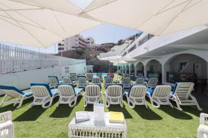 a group of chairs and tables and umbrellas at eó Corona Cedral in Puerto Rico de Gran Canaria