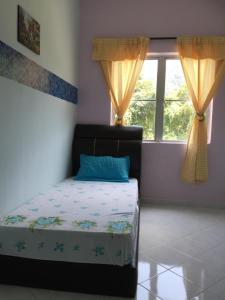 a bedroom with a bed and a window at Pangkor Damai in Pangkor