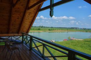 a view of a lake from the porch of a cabin at Agroturystyka Żabi Raj in Pokrzywnica