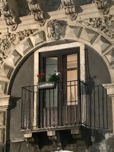 a window with a balcony with two flowers on it at PAPALI loft in Catania