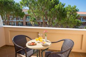a small table with two chairs and drinks on a balcony at Hipotels Playa La Barrosa - Adults Only in Chiclana de la Frontera