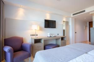a hotel room with a bed and a desk and a chair at Hipotels Playa La Barrosa - Adults Only in Chiclana de la Frontera