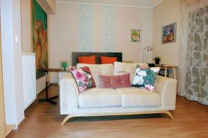 una sala de estar con un sofá blanco con almohadas. en Rino Thessaloniki Apartments, en Tesalónica