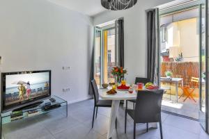 a dining room with a table and a tv at MY CASA FRANCE 82 D - Terrace in Nice