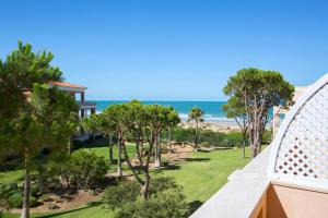 a view of the beach from the balcony of a resort at Hipotels Playa La Barrosa - Adults Only in Chiclana de la Frontera