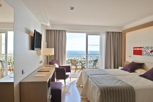 a hotel room with a bed and a view of the ocean at Hipotels Playa La Barrosa - Adults Only in Chiclana de la Frontera