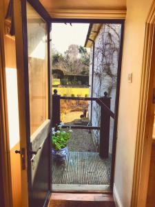 una puerta abierta a un porche con una maceta en The Apple Loft en Westleton