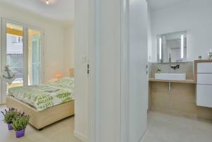 a bedroom with a bed and a bathroom with a sink at MY CASA FRANCE 82 TP - Terrace AC & Parking in Nice