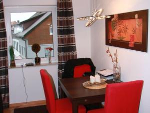 ザンクト・メルゲンにあるFerienwohnung Christaのダイニングルーム(テーブル、赤い椅子付)