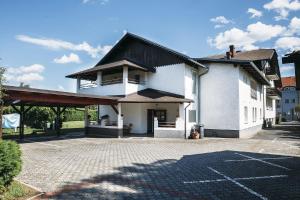 un edificio blanco con techo negro y aparcamiento en Prenočišče Šinkec Nada en Moravske-Toplice