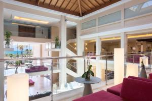 a large building with a balcony with purple furniture at Hipotels Playa La Barrosa - Adults Only in Chiclana de la Frontera