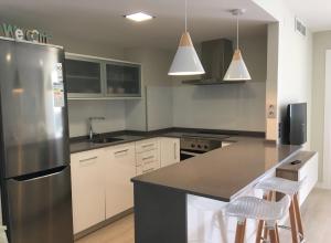 a kitchen with a stainless steel refrigerator and white cabinets at Sorolla 105, luxury, beach, free parking, all services, quite neighborhood, SO in Málaga