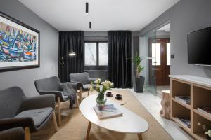 拉賓的住宿－Rialto Residence，客厅配有桌椅和电视。