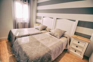 a bedroom with two beds and a window at Apartamentos La Fuente de Enmedio in Suances