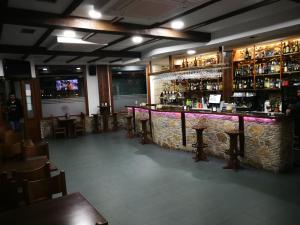 um bar com uma parede de pedra e bancos de bar em Pension Esquina em Melide