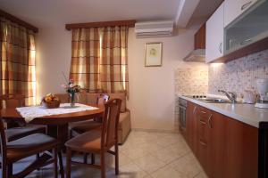 una cocina con mesa y fregadero y una habitación en Apartments Ivana, en Baška Voda