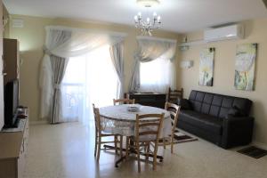 sala de estar con mesa, sillas y sofá en Sea front apartment, en Marsaskala