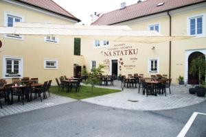 un patio con mesas y sillas frente a un edificio en Penzion U tri statkaru en Dobříš