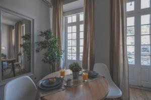 una sala da pranzo con tavolo, sedie e specchio di Impar Studios a Porto