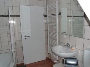 ボルテンハーゲンにあるFerienwohnung Möweの白いバスルーム(シンク、鏡付)