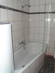 ボルテンハーゲンにあるFerienwohnung Möweのタイル張りのバスルーム(バスタブ、シャワー付)が備わります。