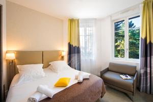 una habitación de hotel con una cama y una silla en Villa Bettina, en La Baule