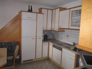a small kitchen with white cabinets and a sink at Ferienhaus Martina in Terfens