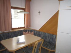 een eetkamer met een tafel en een kruis aan de muur bij Ferienhaus Martina in Terfens